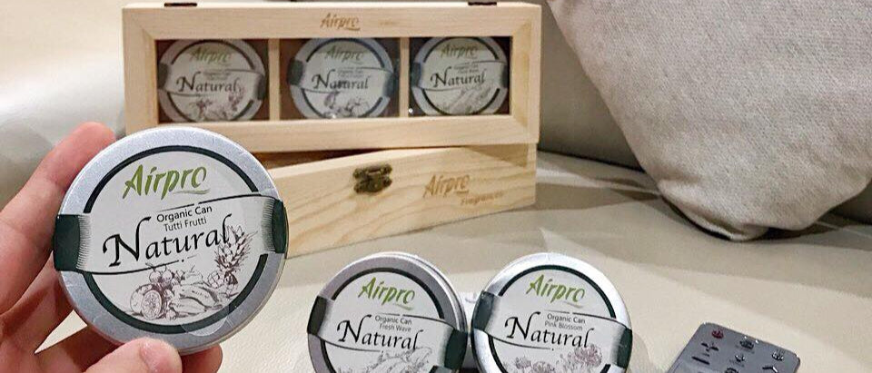 Hand holding an 'Airpro' product on a sofa with more products and packaging in the background.